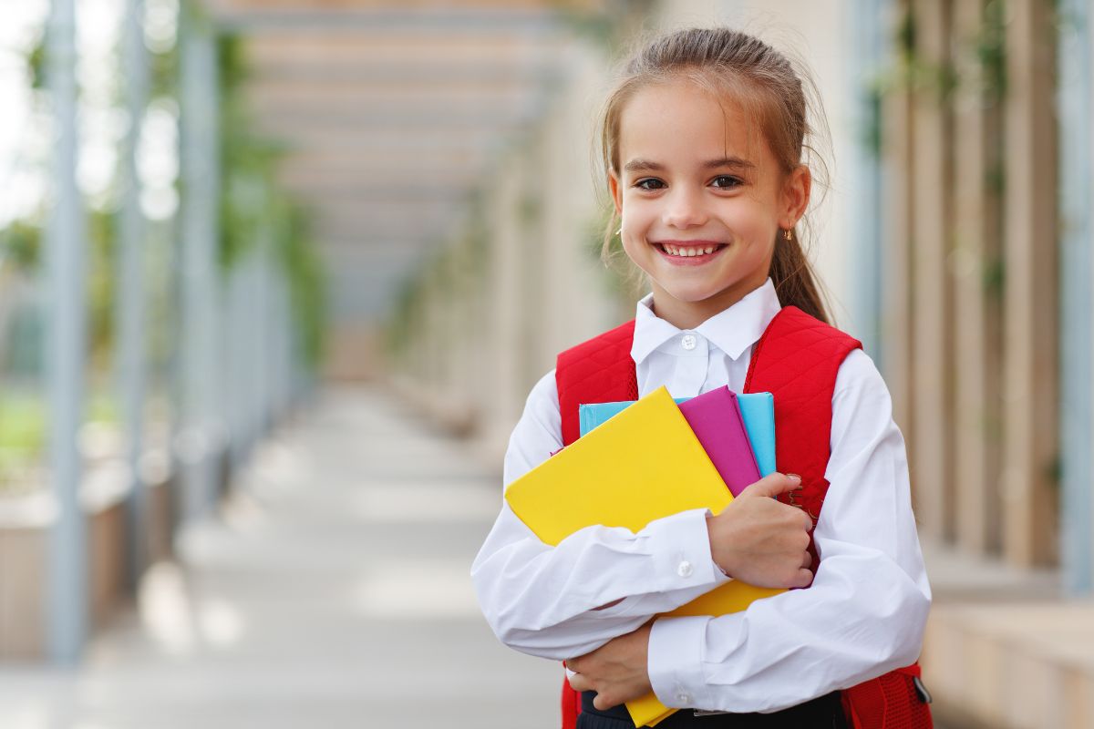 Niña con sus libros antes de entrar a clase de inglés